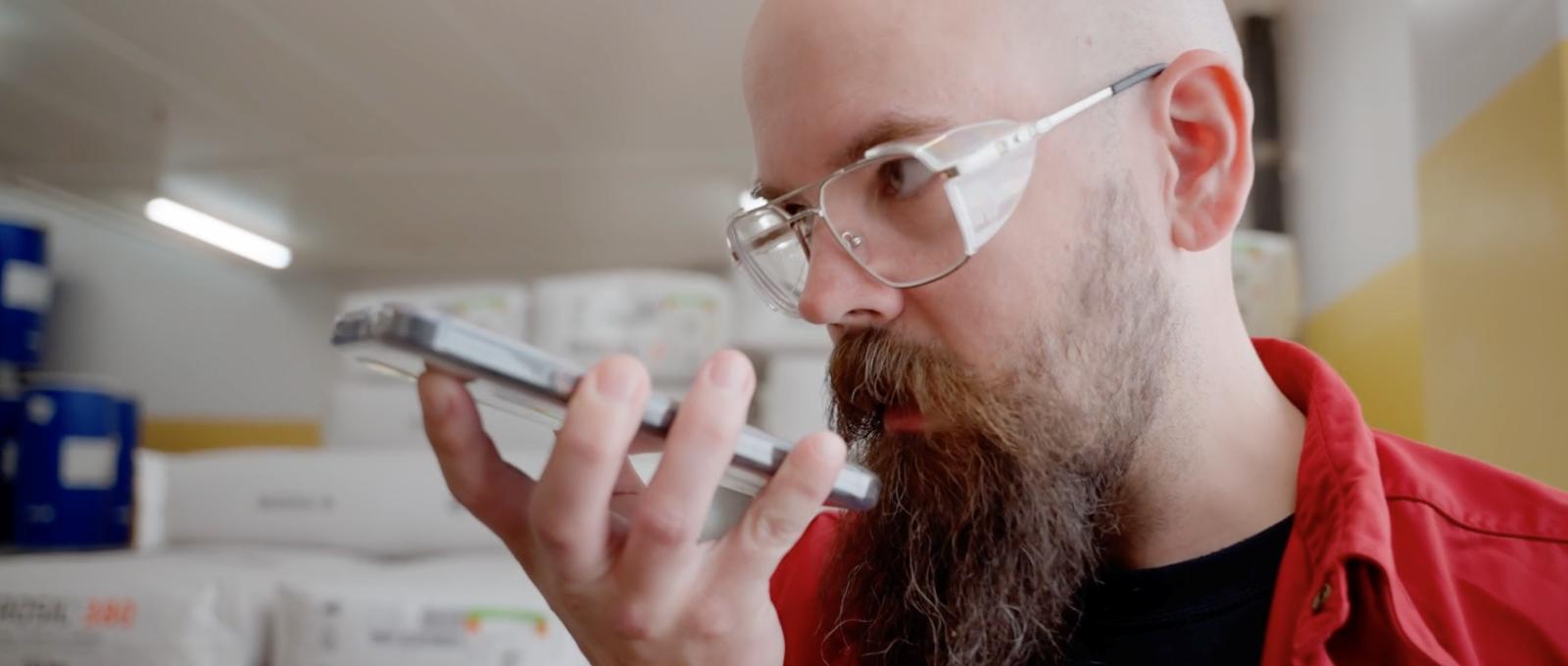 pharmaceutical worker using push to talk app on smartphone for internal communication