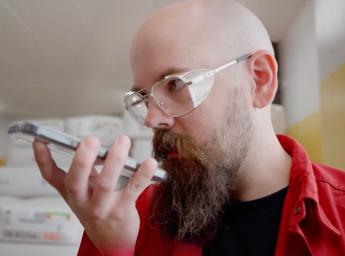 Pharmaceutical worker talking to work team using push to talk app on iphone