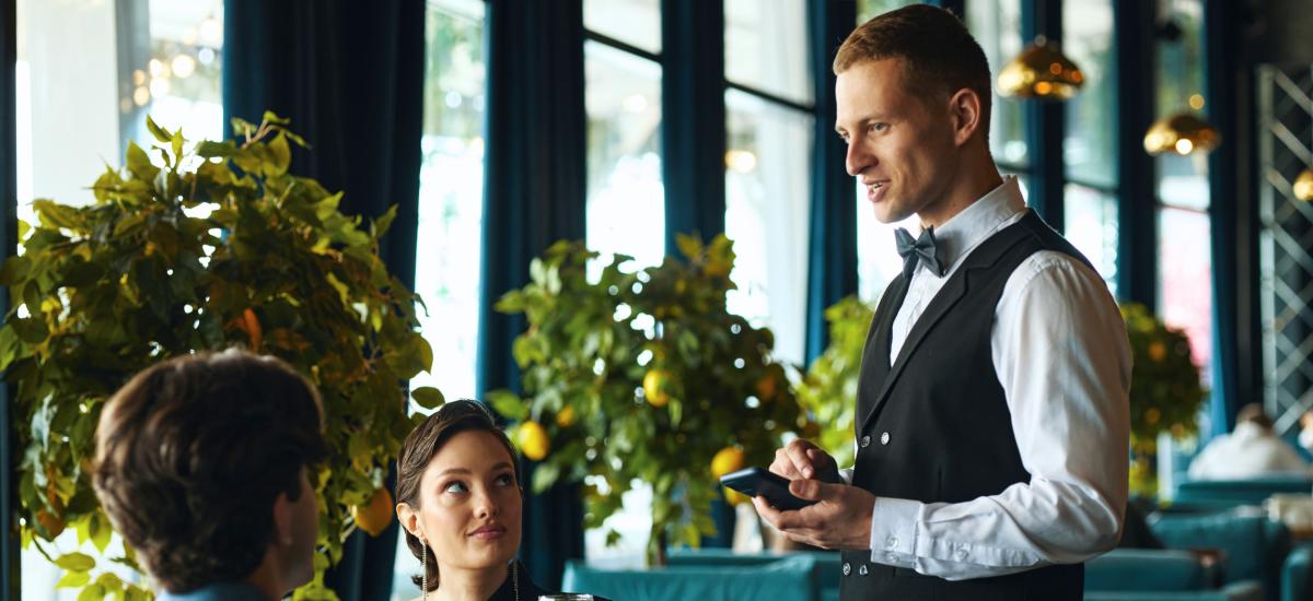 Waiter serving customers at restaurant