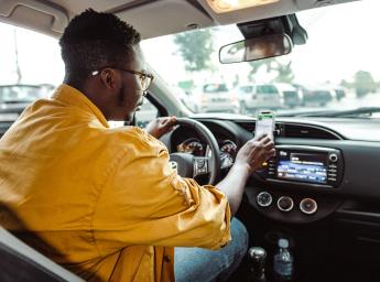Taxi driver using push-to-talk app on smartphone for internal communication.