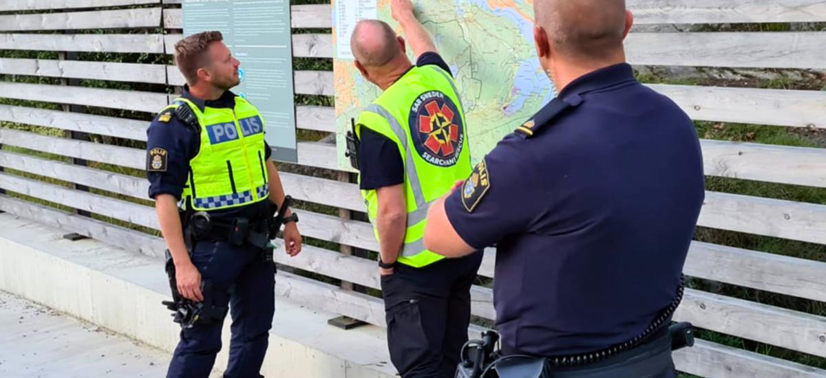 Police officers talking to each other and looking at a map.