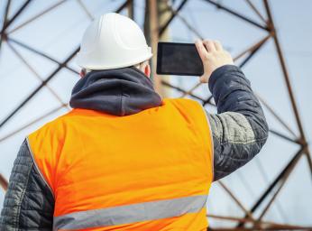 Electrical engineer filmed with tablet PC high voltage tower.
