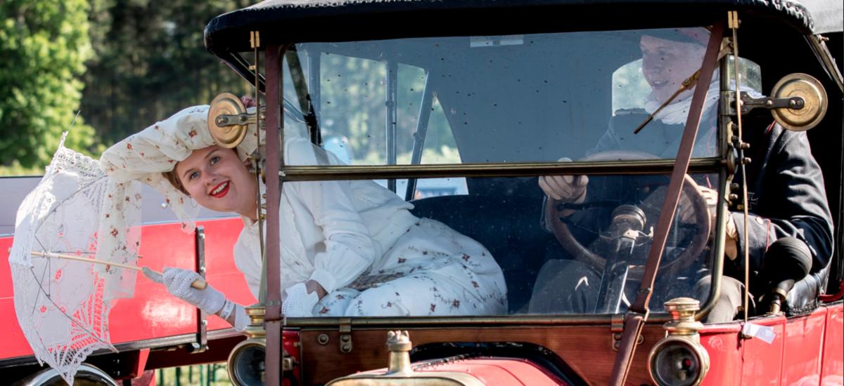 Girl and a boy driving an old car