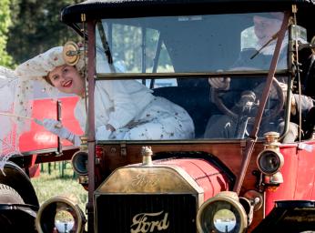 Girl and a boy driving an old car