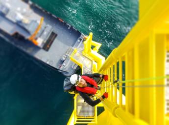 Offshore worker climbing at wind farm