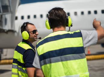 Airport workers wearing Peltor hearing protection with push-to-talk.