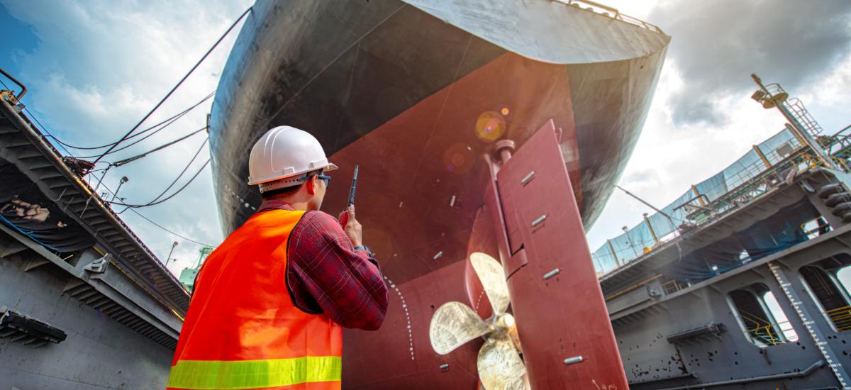Port worker communicating using walkie-talkie.