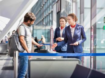 Passenger assisted by airport staff while boarding airplane.