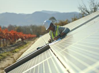 Worker at solar farm using two-way radio for communication.