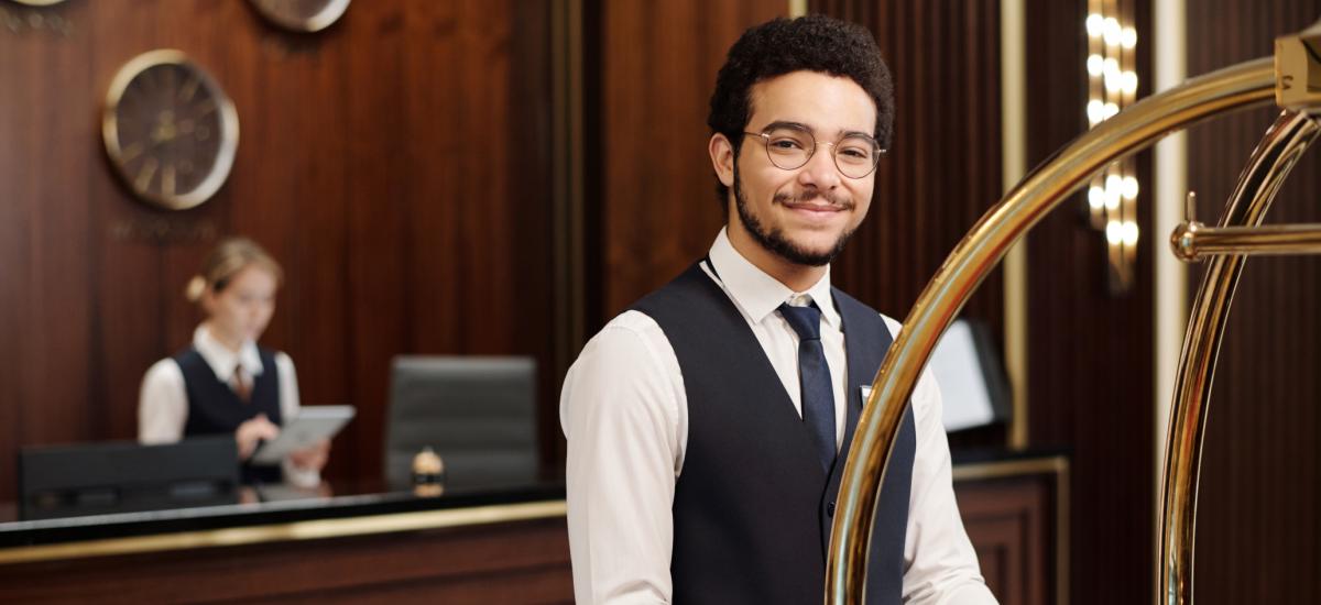 Hotel employee welcoming guests in lobby.