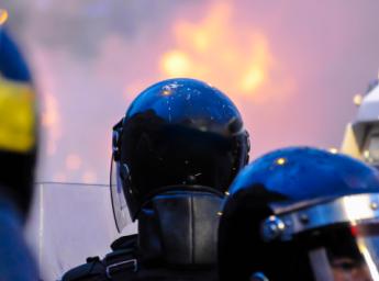 Police officers observing riot as crowd sets van on fire in Belfast.