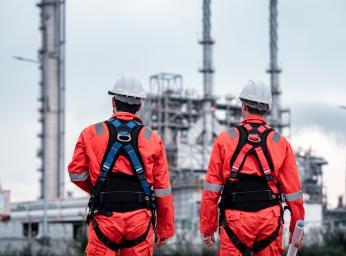 Oil rig workers wearing ATEX safety equipment in hazardous environment.