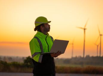 Engineer with laptop survey work in wind turbine farms rotation