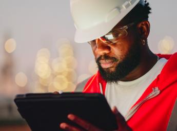 Engineer monitoring operations at oil refinery with tablet.