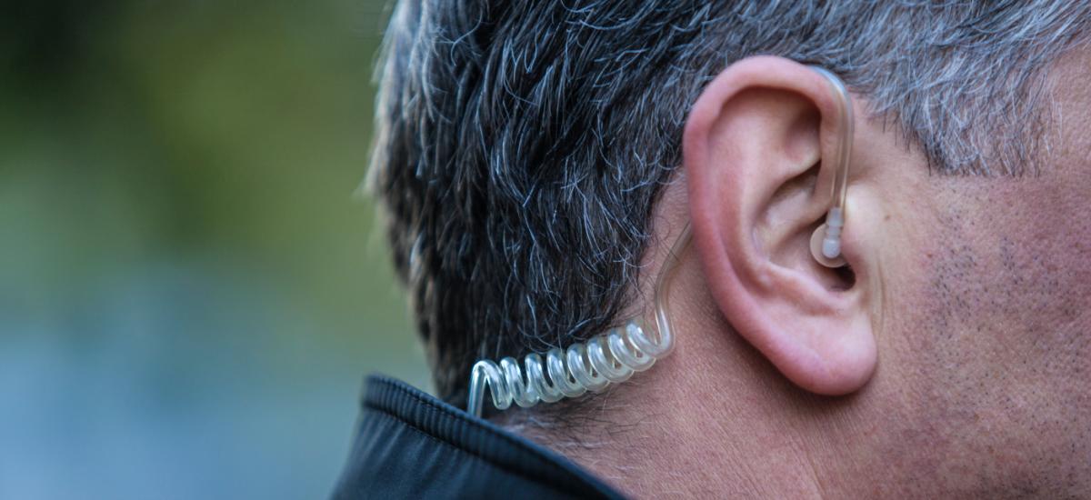 Security guard using listen only headset for push to talk communication