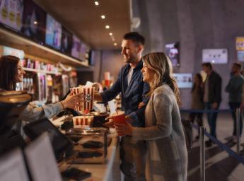 Cinema guests purchasing popcorn and drinks at concession stand
