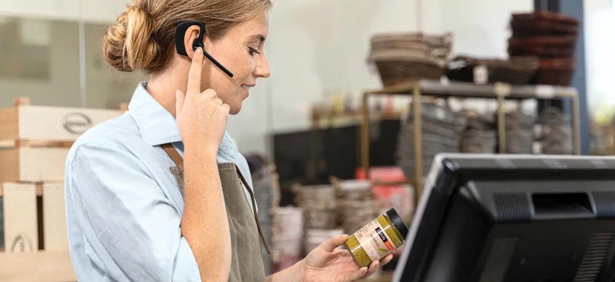 Retail worker using Jabra Perform 45 push-to-talk headset.