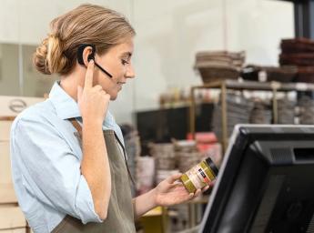 Worker using push-to-talk for team communication in store.