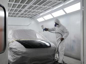 Male worker painting a car.