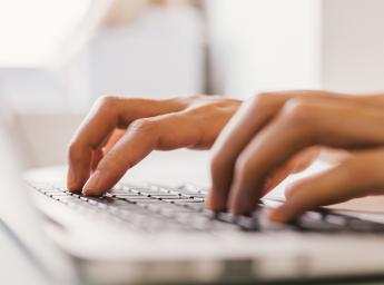 Girl writing on her computer.