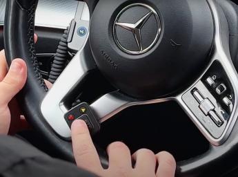 Taxi driver pressing a push to talk button in the car.