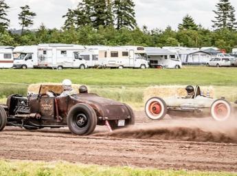 Two old cars racing against each other.